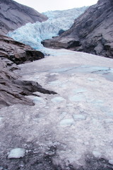 Panorama of a melting glacier between the high cliffs of the Norwegian fjords.