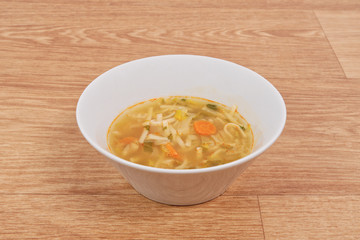 Noodle soup with vegetables on a white