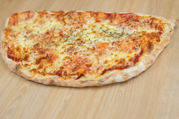 Closeup on traditional fresh pizza, top side view wooden background