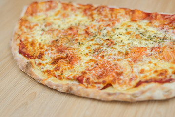 Closeup on traditional fresh pizza, top side view wooden background