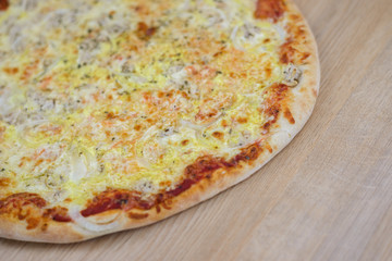 Closeup on traditional fresh pizza, top side view wooden background