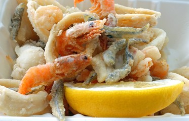 fish fried in a pan in the street food stand