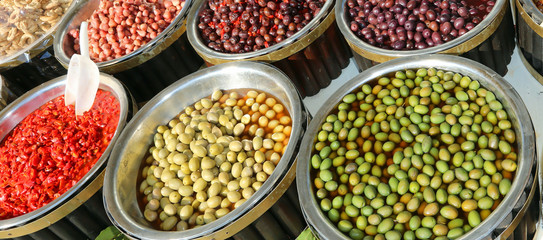 Mediterranean market with big olives and red peppers for sale