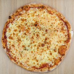 Closeup on traditional fresh pizza, top side view wooden background