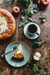 flat lay with cup of coffee, served piece of homemade apple pie on wooden surface