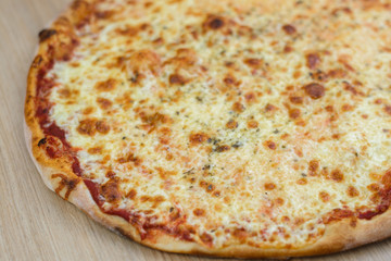 Closeup on traditional fresh pizza, top side view wooden background