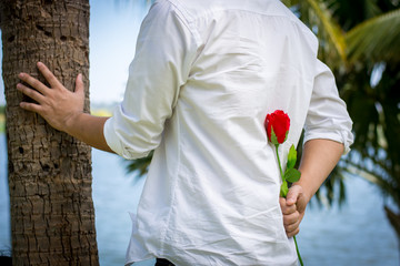 Man holding roses behind.