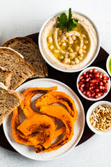 vegan appetizer snack from hummus of white cannellini beans and baked pumpkin on a serving board. Just great food