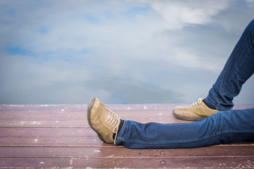 Legs of male tourists on the pier.