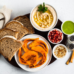 vegan appetizer snack from hummus of white cannellini beans and baked pumpkin on a serving board. Just great food