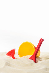 Fototapeta na wymiar Bucket and beach toys in sand isolated on white