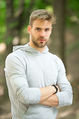Sportsman training with pedometer gadget. Man athlete on strict face posing with sport equipment, nature background. Athlete with bristle with fitness tracker or pedometer. Sport gadget concept