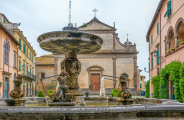 The San Giacomo Cathedral and main fountain in Tuscania, Viterbo, Italy