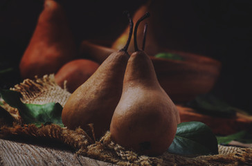Brown pears on vintage wooden background, rustic still life, top view