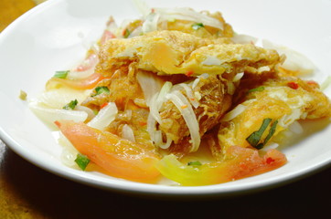fried egg in spicy and sour sauce salad on plate