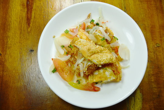 fried egg in spicy and sour sauce salad on plate