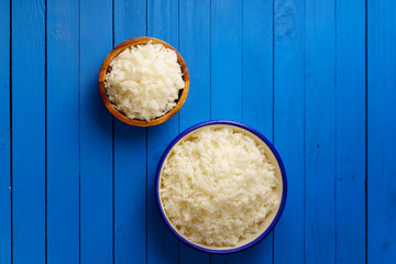 Overhead shot of cooked jasmin rice on blue wooden background