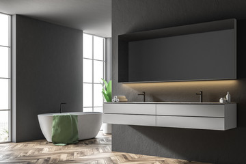 Naklejka na ściany i meble White tub in a black bathroom, armchair, sink side