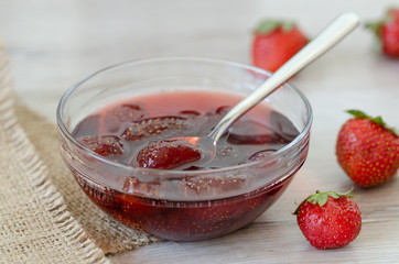 Strawberry jam on the wooden table.