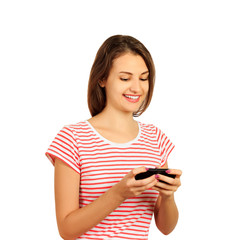 Pleased smiling brunette woman in t-shirt writing message on smartphone. emotional girl isolated on white background