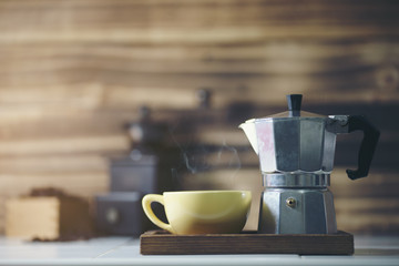  cup of coffee with metal coffee percolator on wooden background,