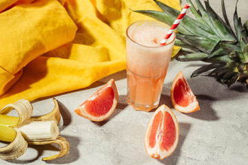 Fresh juice in glass by fruit ingredients on table