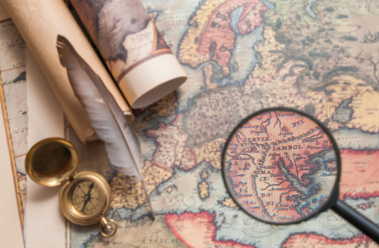Closeup view of a magnifying glass on an old map with vintage items