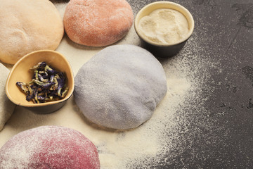 Colorful fresh pasta dough on black table