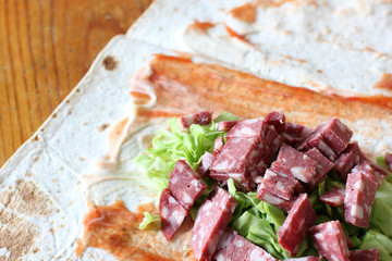 Preparation of shawarma. Meat with vegetables in a bread cake. Fast food.