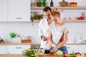 Picture of beautiful man and woman cooking vegetables in kitchen