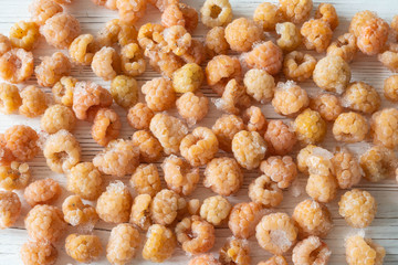 Close-up of yellow raspberry freeze long storage on wooden table