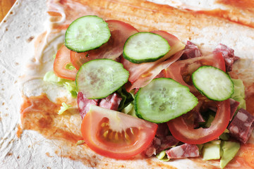 Preparation of shawarma. Meat with vegetables in a bread cake. Fast food.