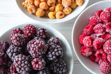 frozen mixed berries on a white plate on a wooden white table