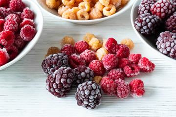 frozen mixed berries on a white plate on a wooden white table