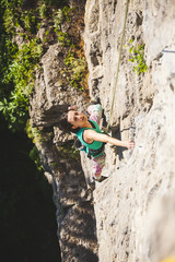 Fototapeta premium The girl climbs the rock.