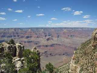 Fototapeta na wymiar Grand Canyon views as seen from the South Rim Trail on a sunny day with blue sky and some clouds 
