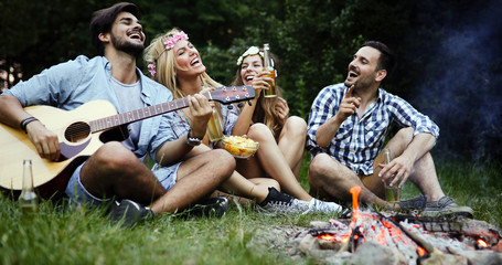 Group of friends listening to guy playing the guitar