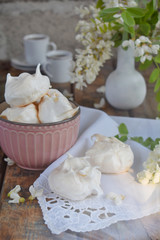 Meringues cookies and cup of coffee. Homemade Meringue kisses drops with acacia flowers. Vintage photo. Copy space