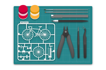 Plastic model with tool kit on cutting mat, bicycle concept design illustration isolated on white background with copy space - 207781764