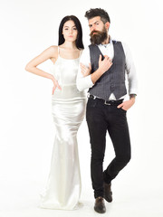 Bearded hipster with bride dressed up for wedding ceremony. Wedding concept. Woman in wedding dress and man in vest. Couple in love, bride and groom in elegant wedding clothes, white background.