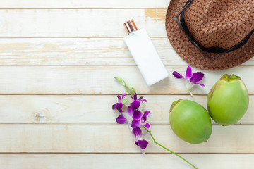 Table top view aerial image of summer & travel beach or sea holiday in the season background concept.Flat lay accessories sun block lotion with orchid & hat on plank white wooden with copy space.