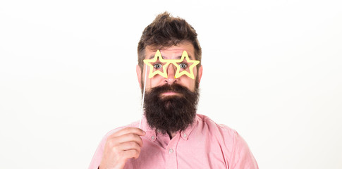 Hipster in pink shirt with stylish beard isolated on white background. Handsome bearded man wearing paper star-shaped glasses, fun concept. Bearded man posing with party accessories at birthday