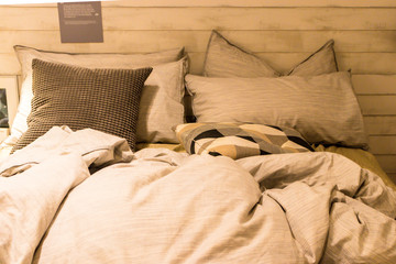 Dirty bed with white pillows and white blanket in the room