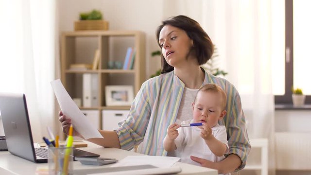 multi-tasking, freelance and motherhood concept - working mother with baby boy at home office