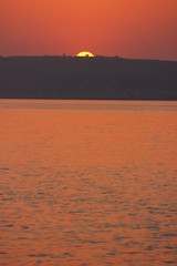 a beautiful view of Gozo Island in the distance at sunset, Malta