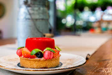 Beautiful cake delicate French patisserie on the wood table. Fruit Cake Classic & New Pairing.