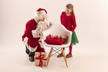 Christmas portrait of cute little newborn baby girl, dressed in christmas clothes, studio shot, winter time