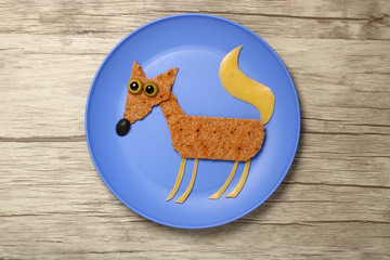 Fox compiled with bread and cheese on blue plate