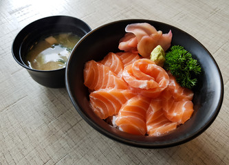 salmon sashimi with rice and miso soup on wood table background.