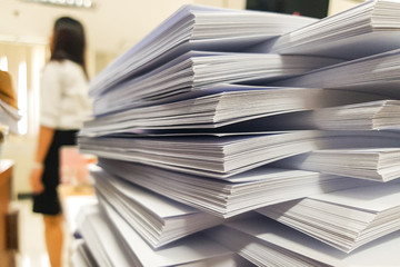 Stacks Paper document with blur working woman on office background.